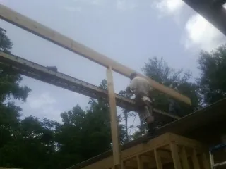 Carpenter setting a ridge beam over a new addition frame — Ice Dam Removal by Roofing Brothers in Forest Grove