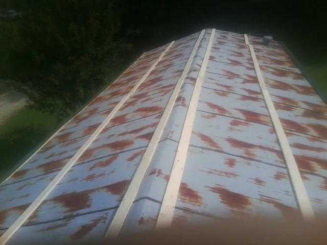 Rusted metal roof panels with new wood purlins before replacement — Storm Damage Roof Repair in Forest Grove by Roofing Brothers