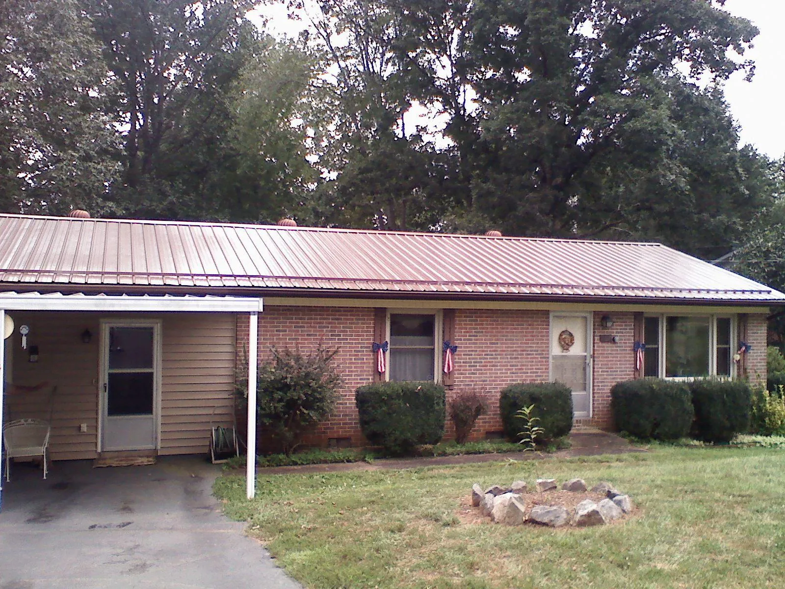 Bronze metal roof and carport on a brick ranch home — Roof Repair work by our crew in Forest Grove